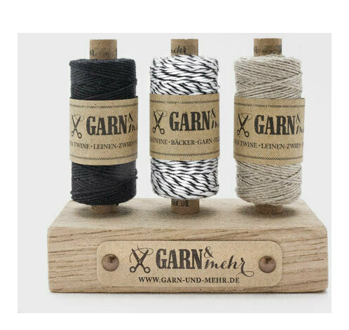 drei Rollen Leinen-Zwirn auf einem Ständer 