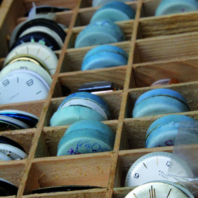 In einer Schublade findet sich eine Sammlung von historischen Ziffernblättern