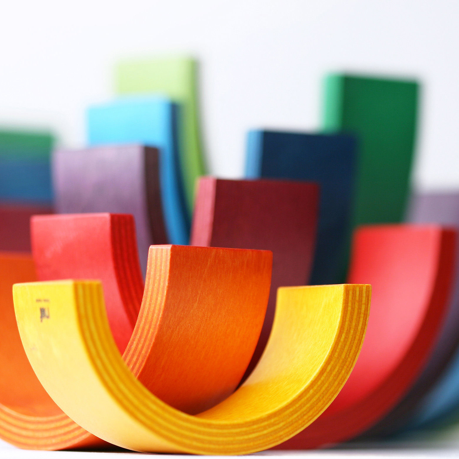 Das Rainbow Spiel von Naef besteht aus neun variablen Bogenelementen aus Holz. Spiel-, Klang- und Kunstobjekt zugleich.